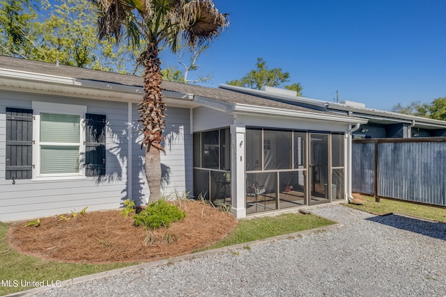 view of property exterior with a sunroom