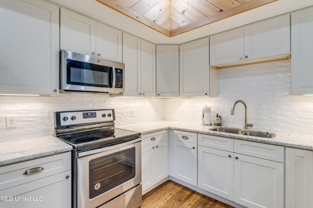 kitchen featuring wood ceiling, white cabinets, appliances with stainless steel finishes, light wood-type flooring, and sink