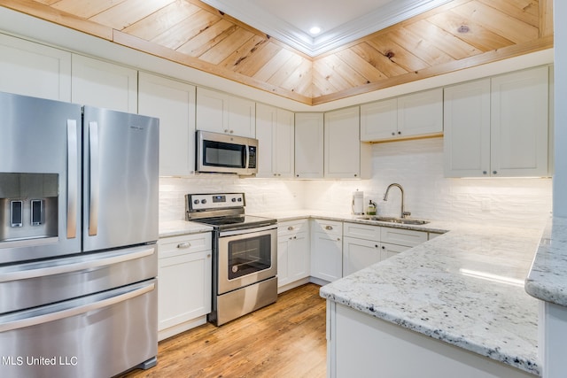 kitchen with white cabinets, light stone counters, light hardwood / wood-style flooring, sink, and stainless steel appliances