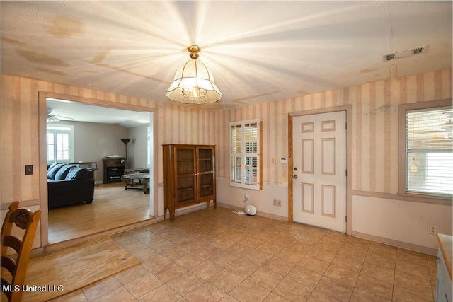 900 Old Benton Rd, Yazoo City, MS 39194 - foyer featuring wallpapered walls, a chandelier, baseboards, and light tile patterned floors