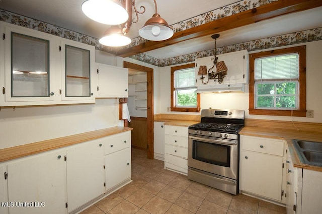 900 Old Benton Rd, Yazoo City, MS 39194 - kitchen featuring stainless steel gas range oven, under cabinet range hood, light countertops, light tile patterned floors, and decorative light fixtures