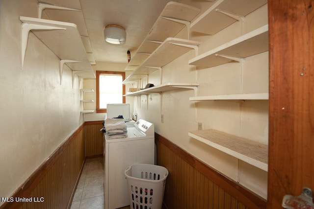 900 Old Benton Rd, Yazoo City, MS 39194 - laundry area with a wainscoted wall, washer and clothes dryer, wood walls, and light tile patterned floors