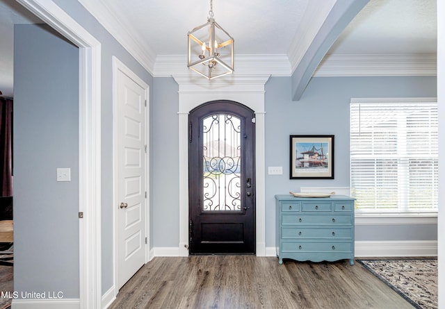 foyer featuring arched walkways, ornamental molding, wood finished floors, and baseboards