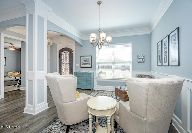 sitting room with arched walkways, wood finished floors, and crown molding