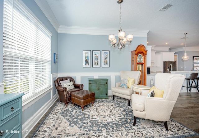 sitting room featuring dark wood-style floors, a chandelier, visible vents, and crown molding