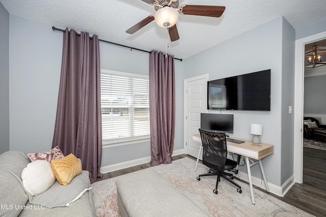 bedroom featuring a textured ceiling, baseboards, and wood finished floors