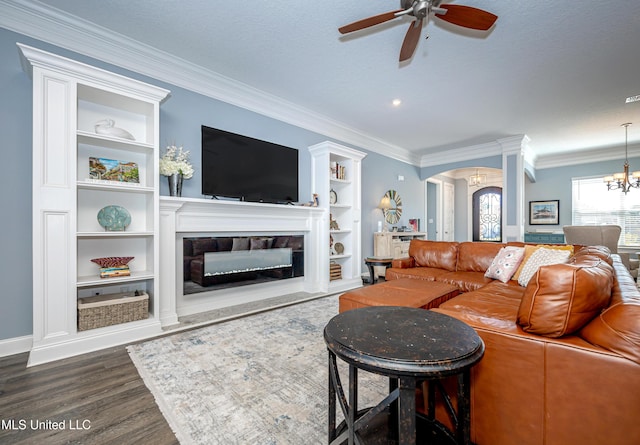 living area featuring arched walkways, dark wood-style flooring, a glass covered fireplace, and crown molding