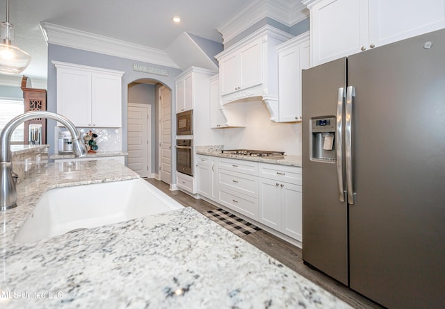 kitchen with dark wood-type flooring, a sink, white cabinetry, appliances with stainless steel finishes, and crown molding