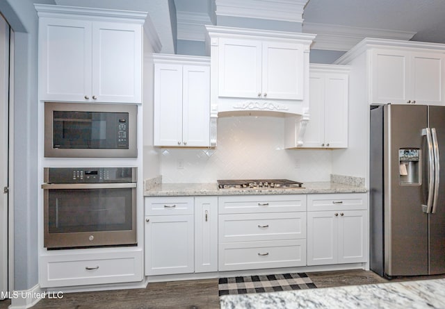 kitchen with stainless steel appliances, white cabinetry, crown molding, and light stone countertops