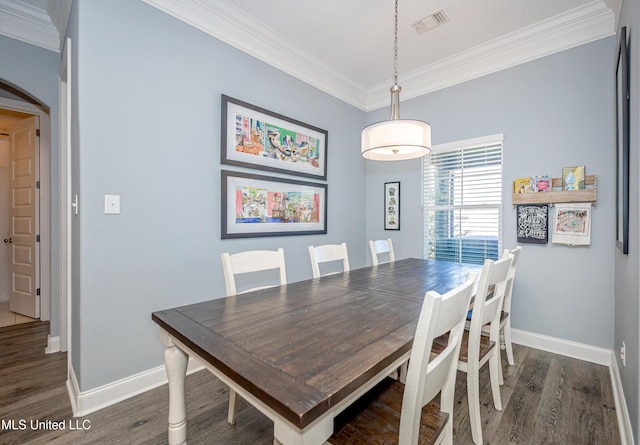 dining area with ornamental molding, dark wood-type flooring, visible vents, and baseboards