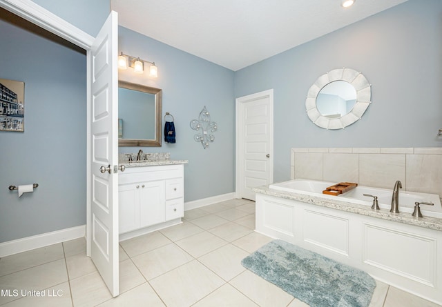 bathroom featuring tile patterned flooring, baseboards, a bath, and vanity