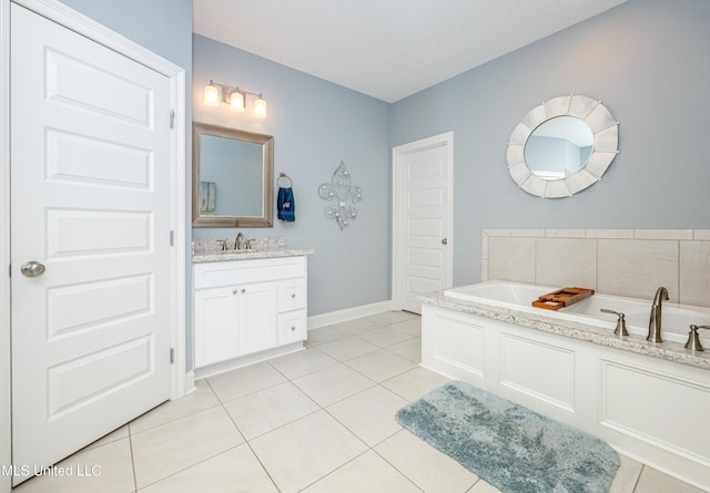 full bath featuring baseboards, vanity, a bath, and tile patterned floors