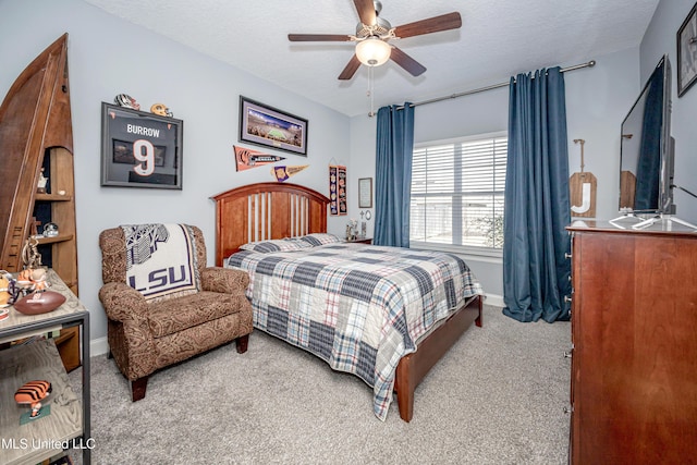 bedroom with carpet floors, a textured ceiling, baseboards, and a ceiling fan