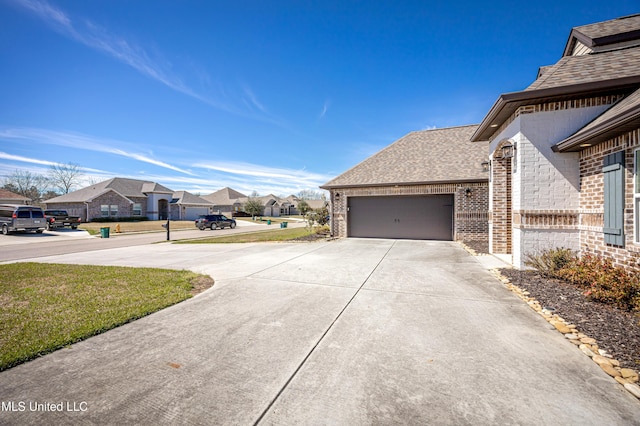 view of home's exterior with driveway, a residential view, roof with shingles, an attached garage, and brick siding