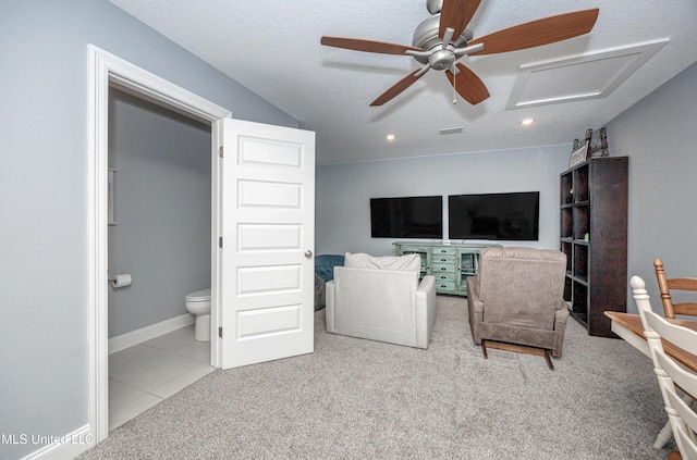 carpeted living room featuring a textured ceiling, ceiling fan, visible vents, baseboards, and attic access