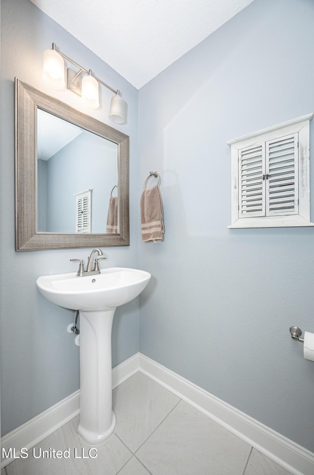 bathroom with baseboards and tile patterned floors