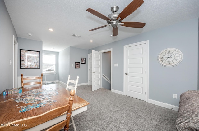 interior space with baseboards, visible vents, a ceiling fan, a textured ceiling, and carpet flooring