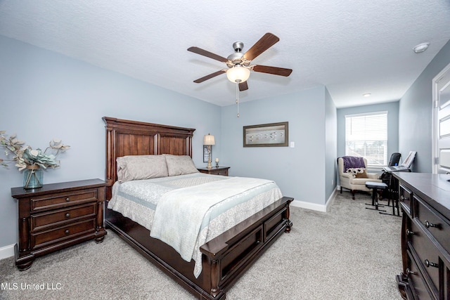 bedroom with a ceiling fan, light carpet, a textured ceiling, and baseboards