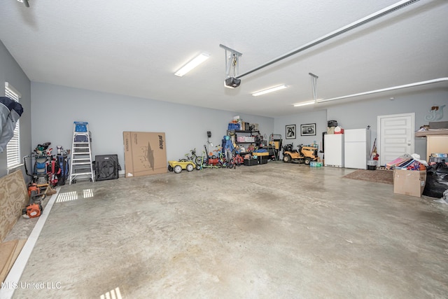 garage with a garage door opener and freestanding refrigerator