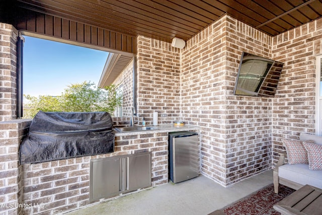 view of patio / terrace featuring exterior kitchen and a sink