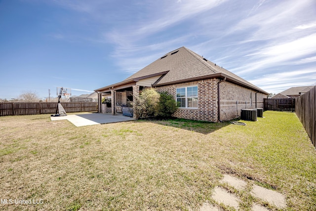 back of house with a fenced backyard, a lawn, a patio, and brick siding