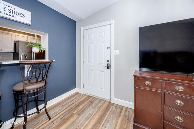 foyer entrance featuring light hardwood / wood-style flooring and lofted ceiling