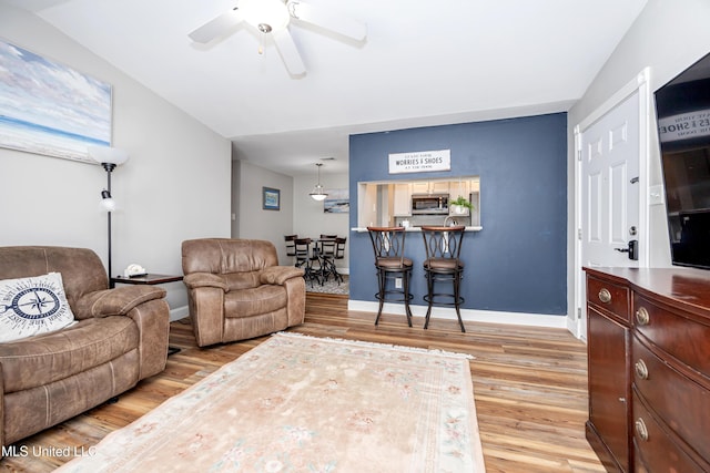 living room with light hardwood / wood-style floors and ceiling fan