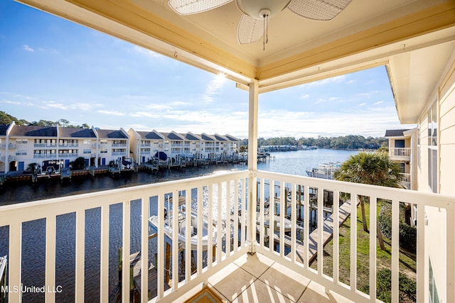 balcony with ceiling fan and a water view