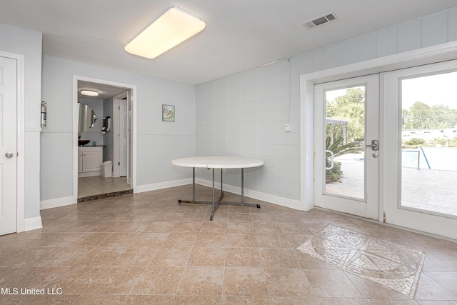 doorway to outside with light tile patterned floors and french doors