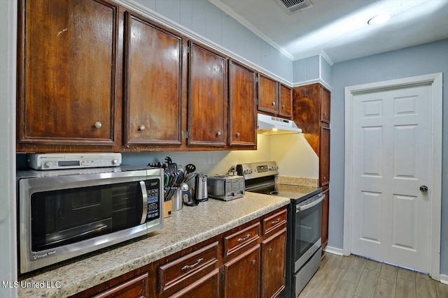 kitchen featuring crown molding, stainless steel appliances, and light hardwood / wood-style floors