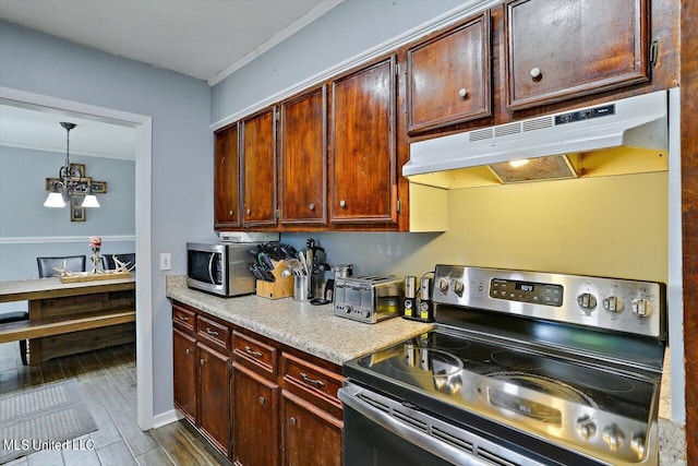 kitchen with appliances with stainless steel finishes and decorative light fixtures