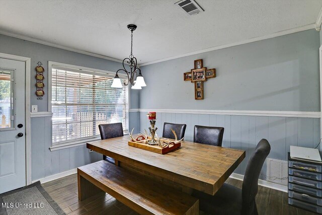 dining area with ornamental molding, dark hardwood / wood-style floors, a chandelier, and a textured ceiling