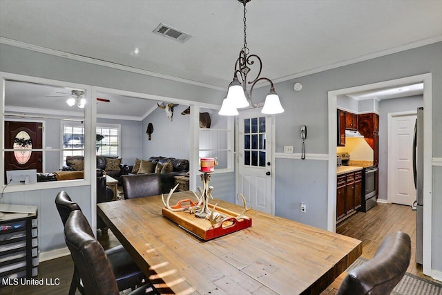 dining space with crown molding, ceiling fan, and dark hardwood / wood-style flooring