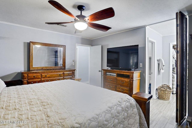 bedroom featuring ceiling fan, crown molding, a textured ceiling, and hardwood / wood-style flooring