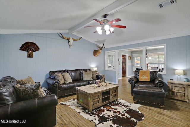 living room featuring ceiling fan, wood-type flooring, and vaulted ceiling with beams