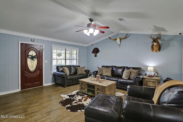 living room with ceiling fan, ornamental molding, dark hardwood / wood-style flooring, and vaulted ceiling with beams