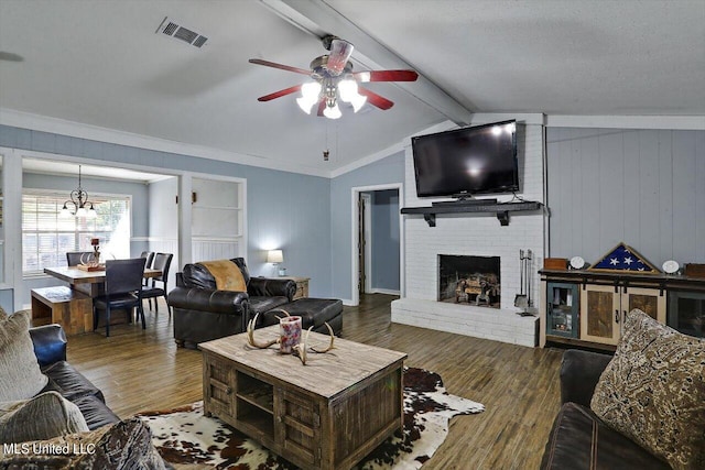 living room with a fireplace, vaulted ceiling with beams, hardwood / wood-style flooring, ceiling fan, and crown molding