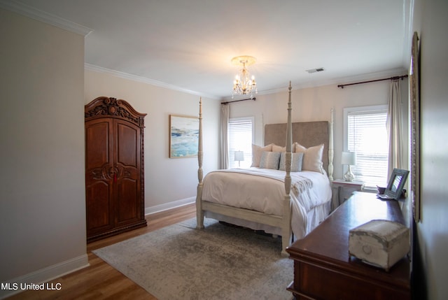 bedroom with hardwood / wood-style flooring, multiple windows, crown molding, and a notable chandelier