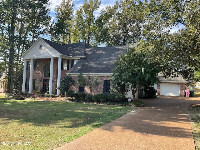 greek revival house featuring a garage and a front lawn