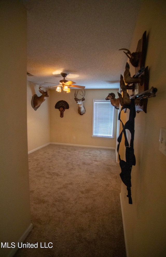 unfurnished living room featuring carpet, a textured ceiling, and ceiling fan