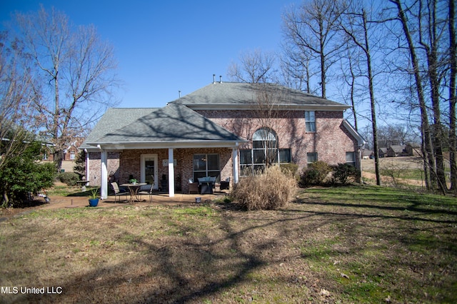 back of property featuring a lawn and a patio