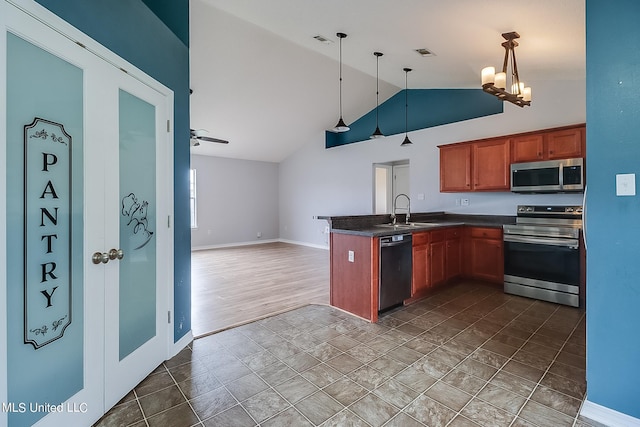 kitchen featuring hanging light fixtures, kitchen peninsula, wood-type flooring, sink, and appliances with stainless steel finishes