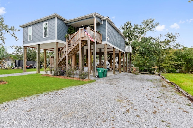 coastal home featuring a front lawn and a carport