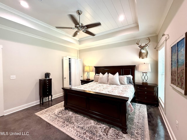 bedroom featuring a raised ceiling, baseboards, concrete floors, a ceiling fan, and ornamental molding