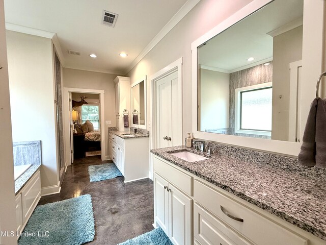 full bath featuring ensuite bath, healthy amount of natural light, crown molding, finished concrete floors, and two vanities
