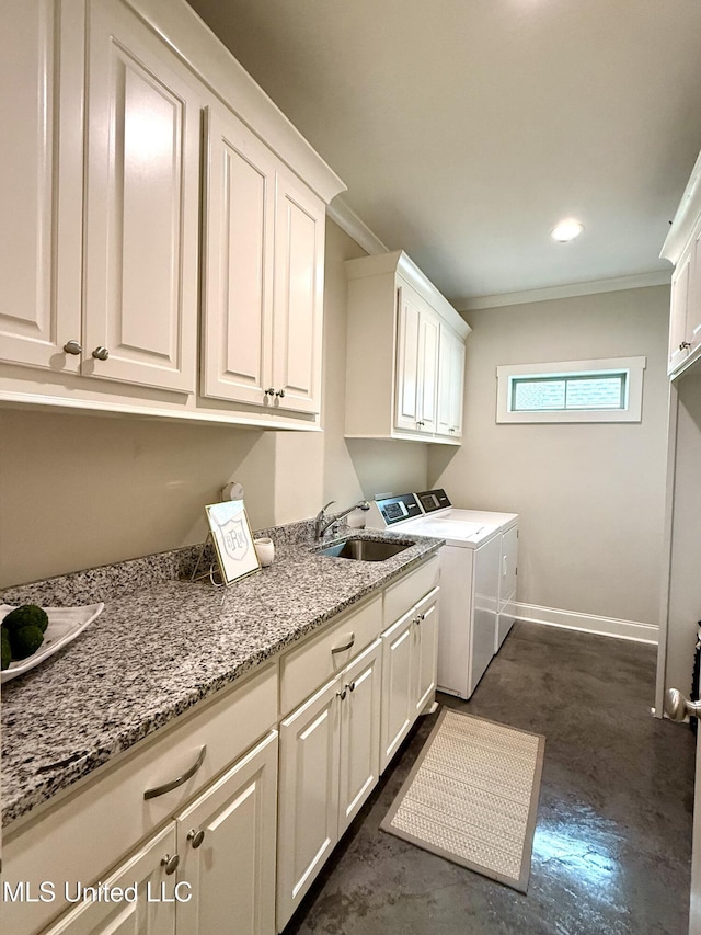 clothes washing area featuring cabinet space, separate washer and dryer, crown molding, and baseboards
