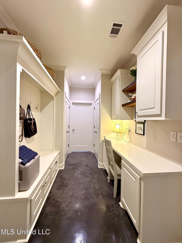 mudroom featuring built in study area, ornamental molding, baseboards, and recessed lighting
