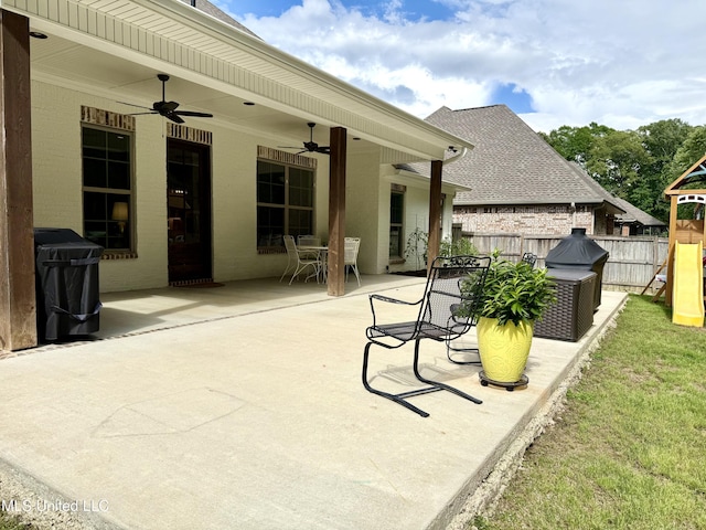 view of patio / terrace with ceiling fan, fence, a playground, and outdoor dining area