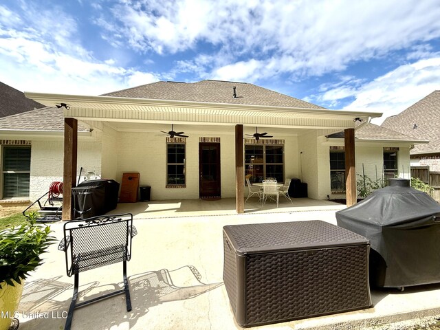 back of property featuring a ceiling fan, roof with shingles, outdoor dining area, and a patio area