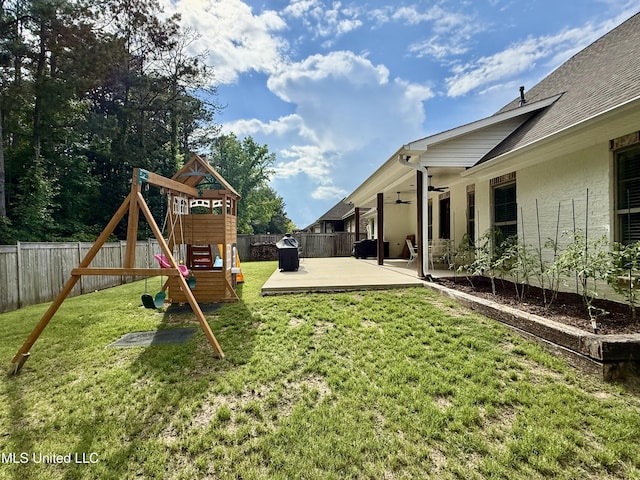 view of yard featuring a ceiling fan, a playground, and a patio